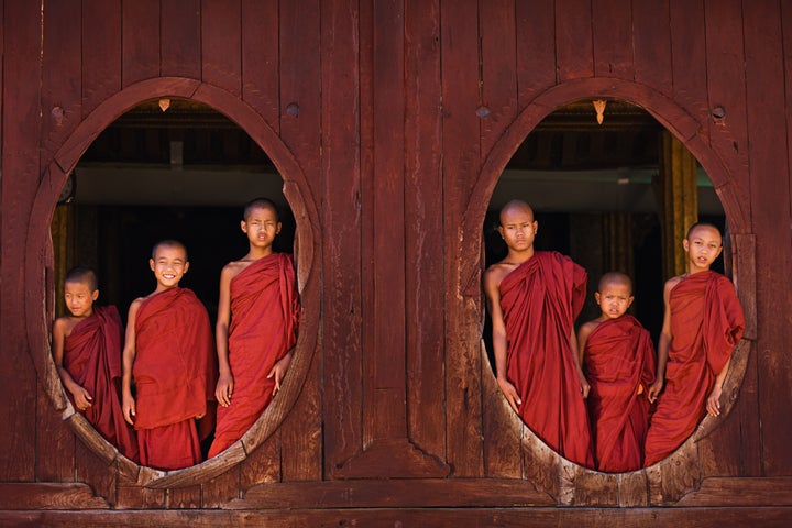 Novice Buddhist monks looking out of the windows