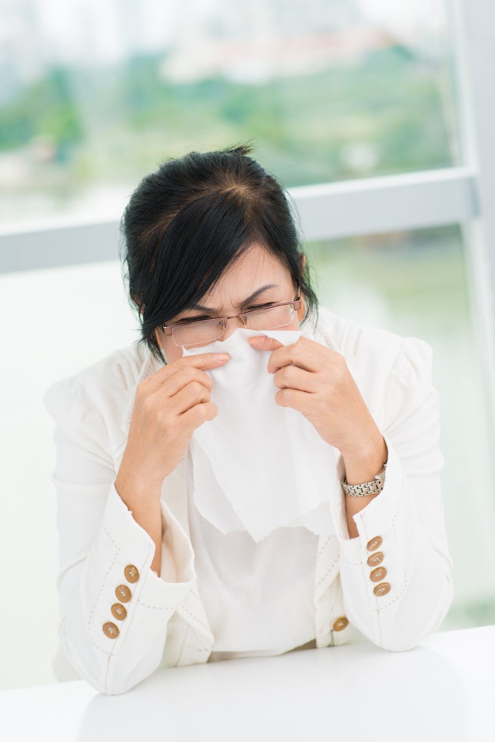 portrait of woman sneezing in a ...