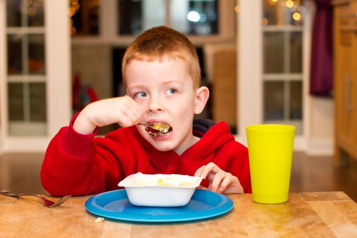 child eating an unhealthy processed dinner in front of the TV