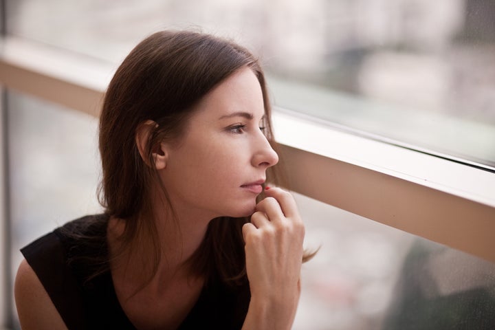 sad girl sitting at the window