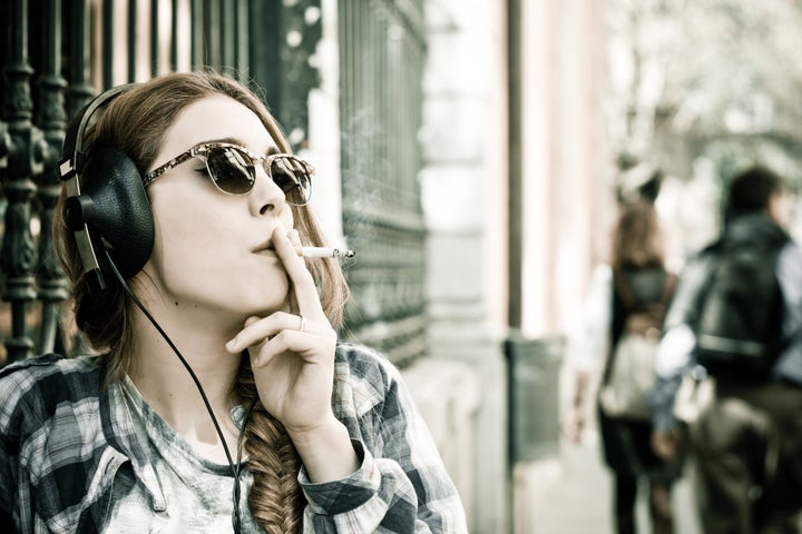 Beautiful woman with headphones on city