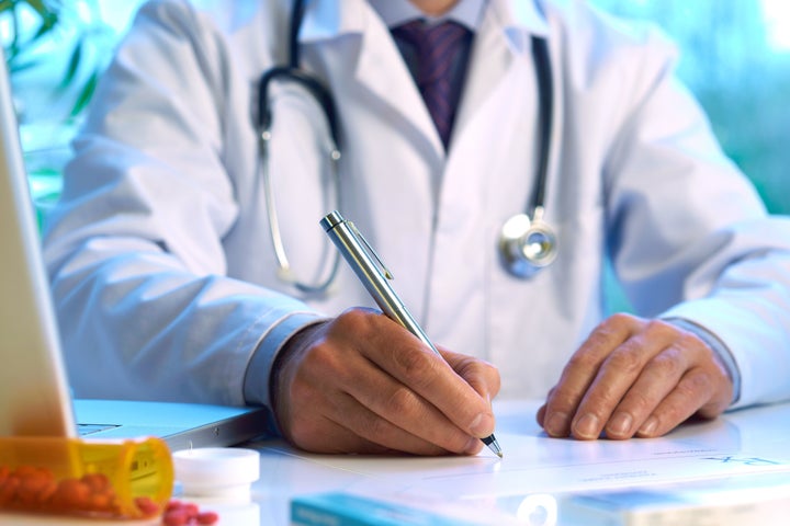 Doctor writing prescription selective focus