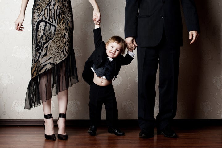 happy little boy holding his parents by the hand