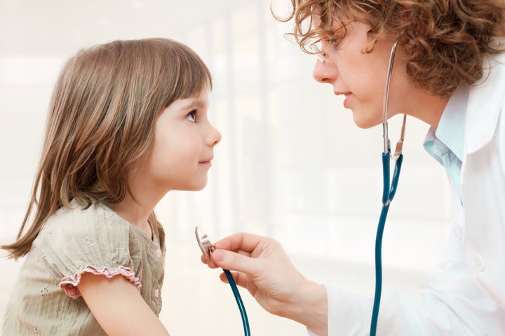 Female doctor examining little girl