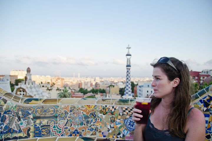Woman drinking sangria and looking at Barcelona city.