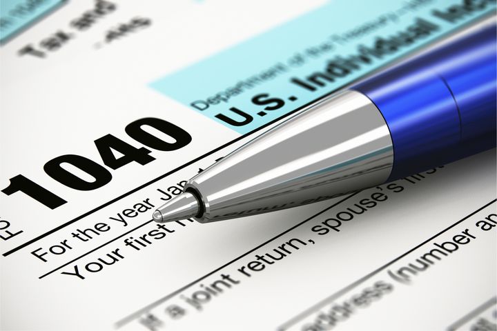 Tax form business financial concept: macro view of individual return tax form and blue metal ballpoint pen