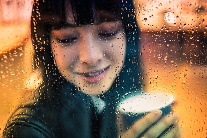 Young woman drinking hot coffee during a winter rainy day