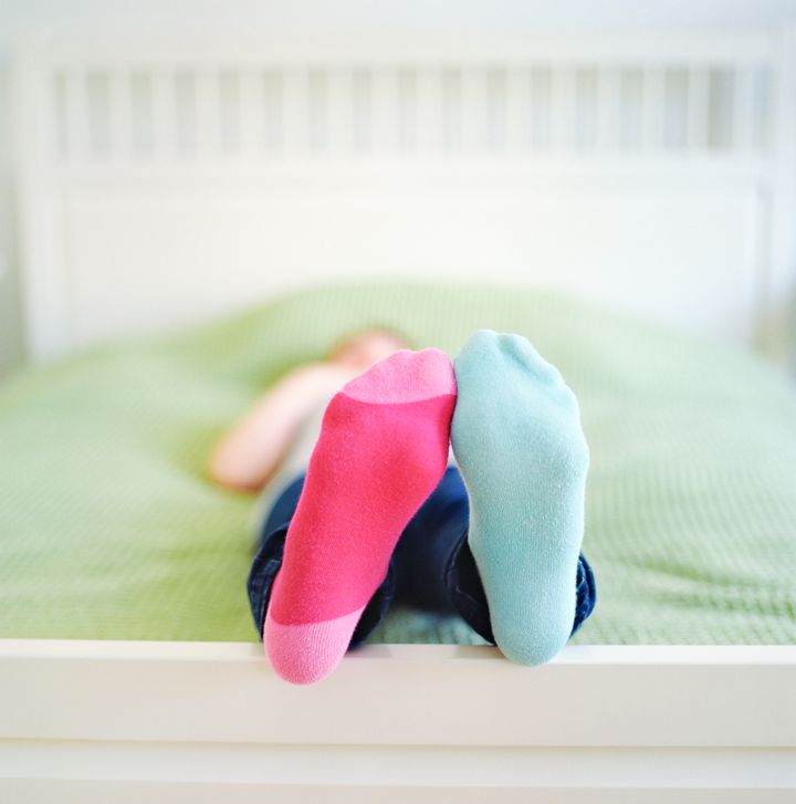Girl lying on the bed with mismatched socks