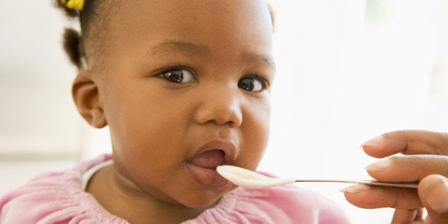 Mother feeding baby food to baby