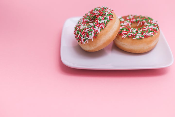 Two donuts with sprinkles on a plate