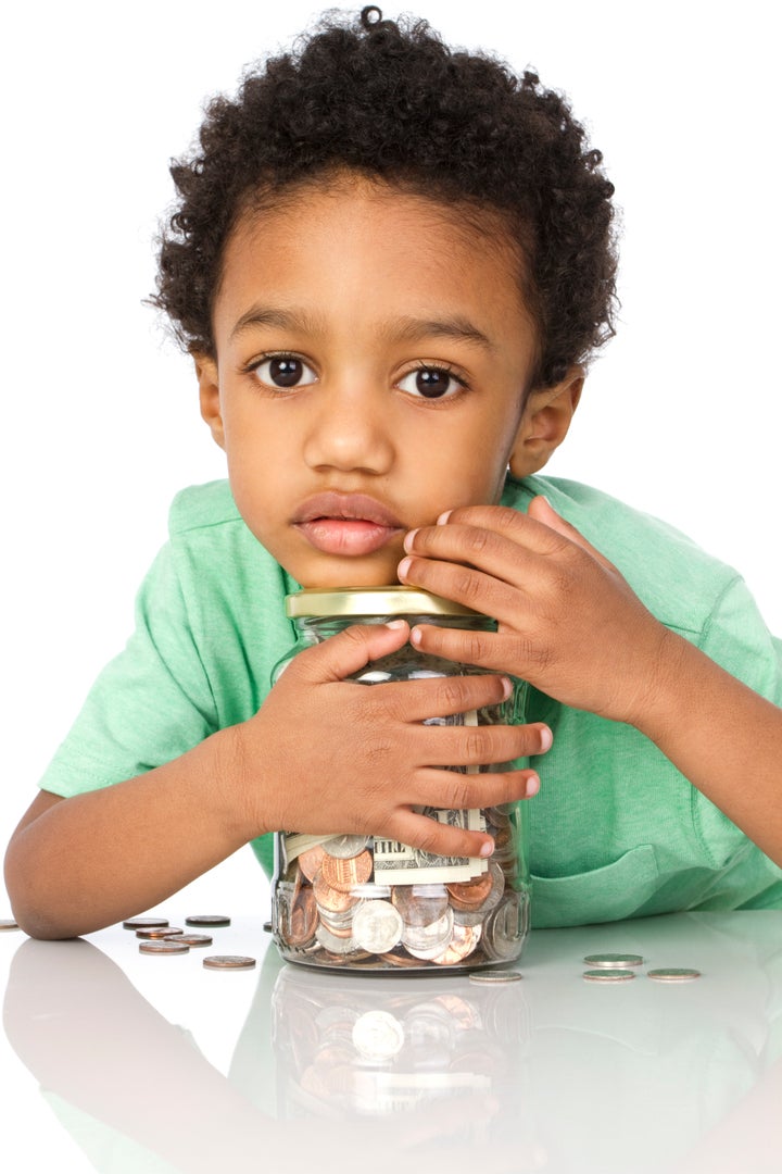 little boy with a jar of money isolated on white background