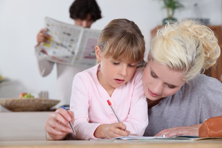 Mother helping her daughter with her homework.