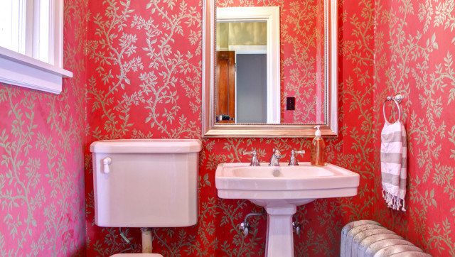 Luxury red and gold small bathroom with silver radiator.