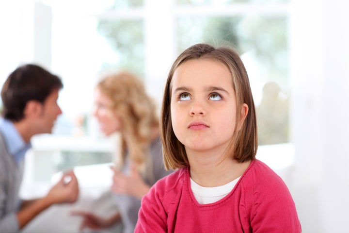 Portrait of upset child with parent's fighting