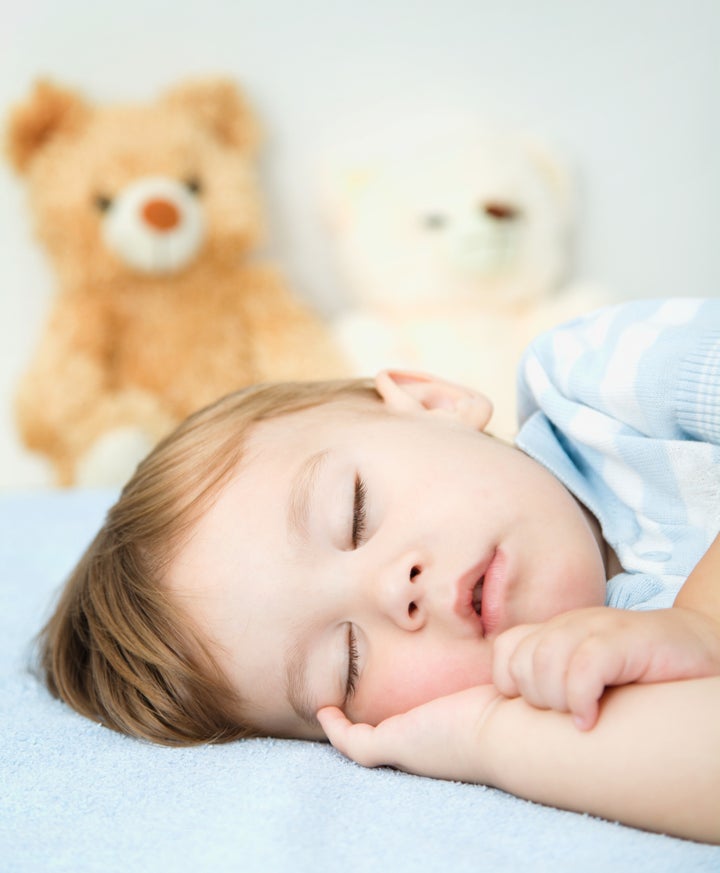 Cute little boy is sleeping on a white pillow