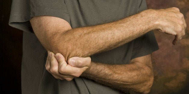 closeup of man massaging elbow