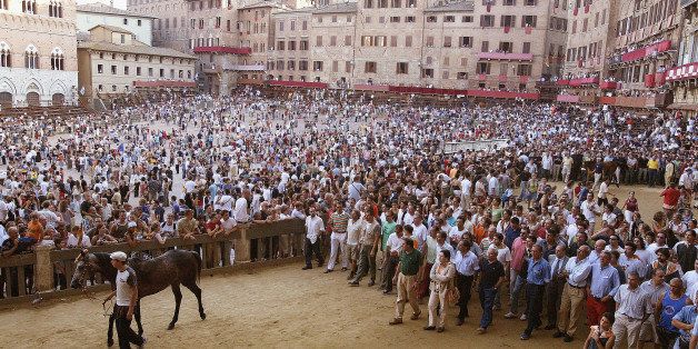 SIENA, ITALY - JUNE 30: One of the ten 'Contrada' (ancient districts of Siena) leave the Piazza del Campo after the finish of the third proof race of the 'Palio di Siena' June 30, 2003 in Siena, Italy. The medieval horse race and pageant pits the ancient districts of Siena against each other in competition for the victory banner. (Photo by Luca Lozzi/Getty Images)