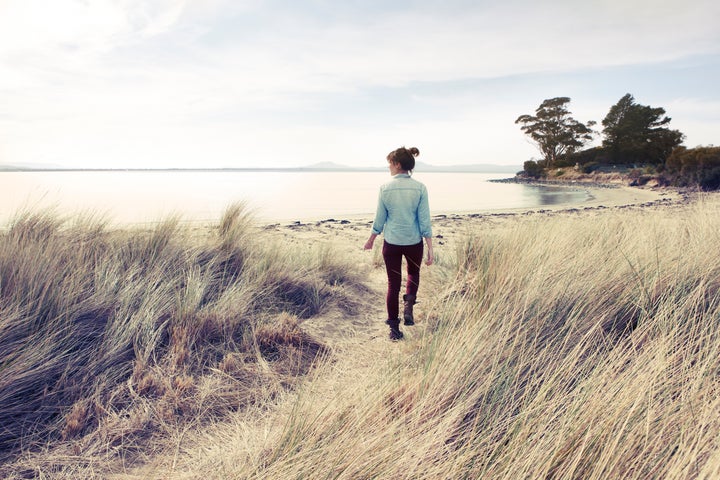 Woman walking onto beach in winter