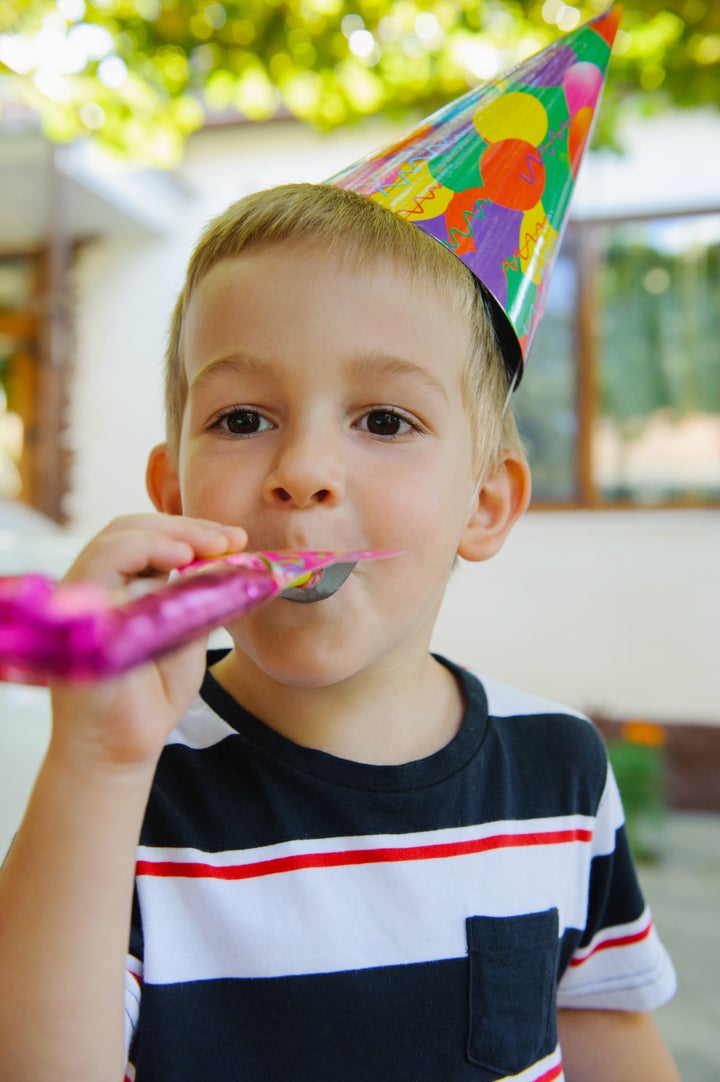 Little child in cap at outdoors birthday party