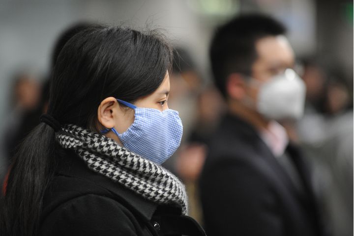 People wear masks to protect themselves from bird flu in the Metro underground system in Shanghai on April 9, 2013. The World Health Organisation said on April 8 there is no evidence China's new H7N9 strain of bird flu is spreading between humans, as the death toll rises and airline and tourism shares slumped. AFP PHOTO/Peter PARKS (Photo credit should read PETER PARKS/AFP/Getty Images)