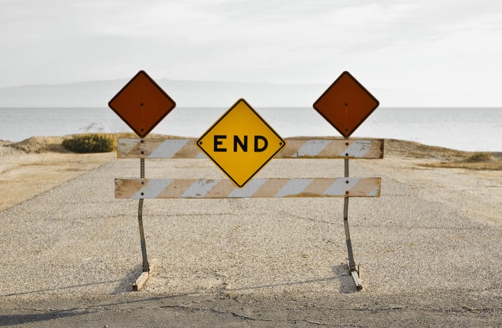 A faded sign sits at the end of the road near the Salton Sea in California.