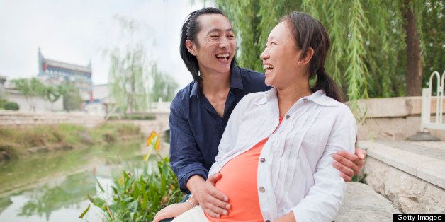 Chinese man rubbing pregnant wife's belly