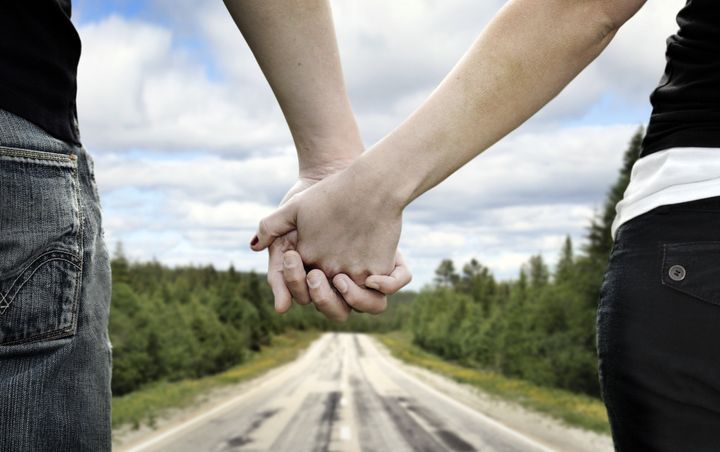 a couple holds hands on a...