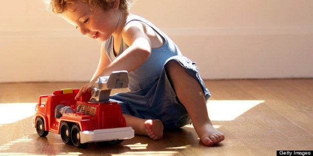 baby boy playing with toy fire engine