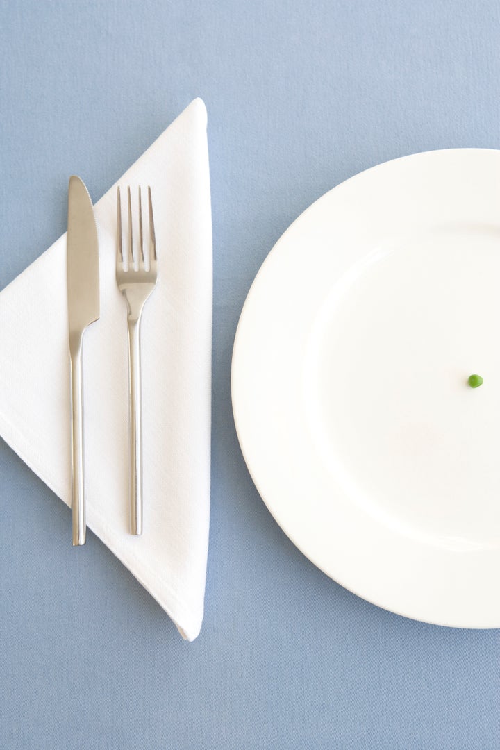 Place setting with green pea in center of plate, overhead view