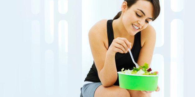 Young woman holding a salad to take away: healthy eating concept.