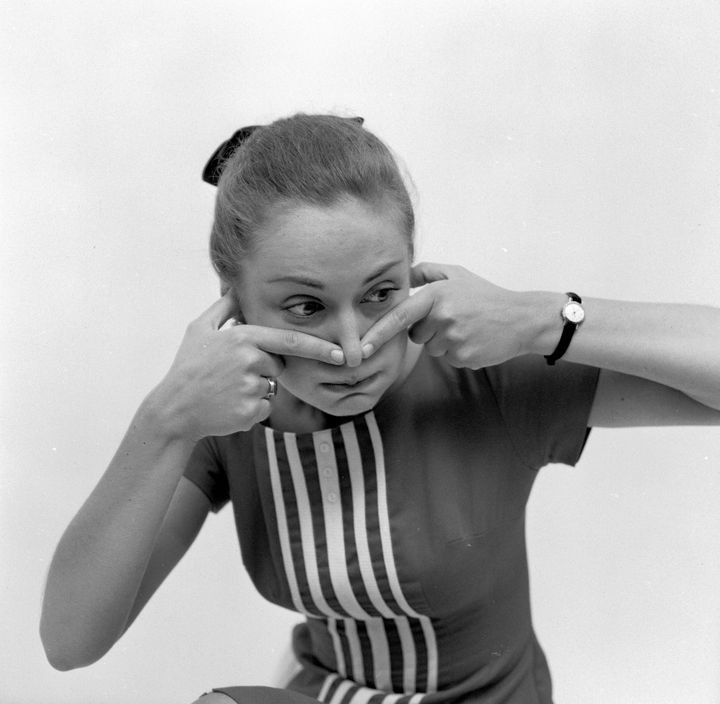 A variation on a theme for curing hiccups, a young woman plugs up her ears and nose and holds her breath.