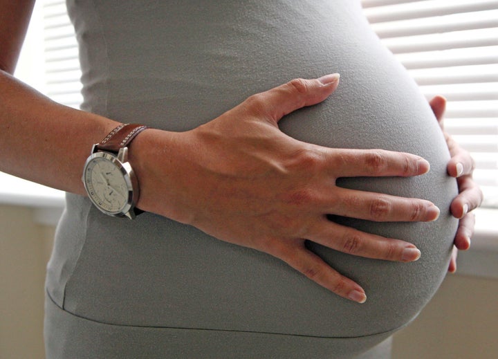 File photo dated 25/06/08 of a woman holding her stomach, eight months into her pregnancy.