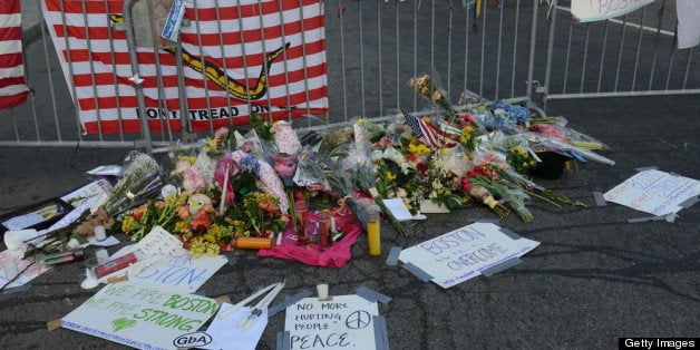 BOSTON - APRIL 17: Signs, flowers and candles make up a makeshift memorial at the corner of Berkeley and Boylston Street for the victims of the Boston Marathon bombing April 17, 2013 in Boston, Massachusetts. Boston continues to get back to normal, as businesses and streets are reopened following a two bomb explosion at the finish line of the marathon that killed 3 people and injured hundreds more. (Photo by Darren McCollester/Getty Images)