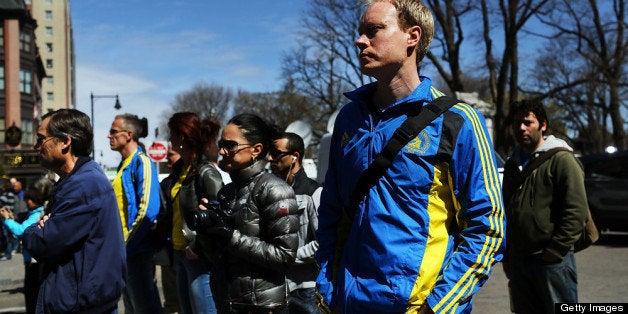 BOSTON, MA - APRIL 16: People congregate, including many runners, at a security gate near the scene of yesterday's bombing attack at the Boston Marathon on April 16, 2013 in Boston, Massachusetts. The twin bombings, which occurred near the marathon finish line, resulted in the deaths of three people while hospitalizing at least 128. The bombings at the 116-year-old Boston race, resulted in heightened security across the nation with cancellations of many professional sporting events as authorities search for a motive to the violence. (Photo by Spencer Platt/Getty Images)