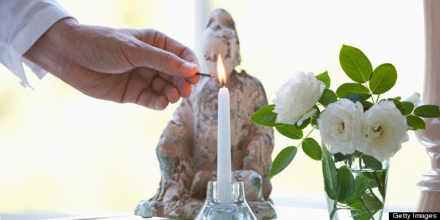 Man lighting candle in living room