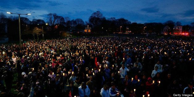 BOSTON, MA - APRIL 16: People gather with candles during a vigil for eight-year-old Martin Richard, from Dorchester, who was killed by an explosion near the finish line of the Boston Marathon on April 16, 2013 at Garvey Park in Boston, Massachusetts. The twin bombings resulted in the deaths of three people and hospitalized at least 128. The bombings at the 116-year-old Boston race resulted in heightened security across the nation with cancellations of many professional sporting events as authorities search for a motive to the violence. (Photo by Jared Wickerham/Getty Images)