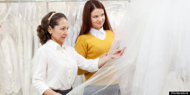 shop assistant helps the bride ...