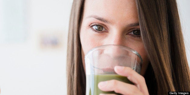 Mother with daughter (6-11 months) drinking vegetable smoothie