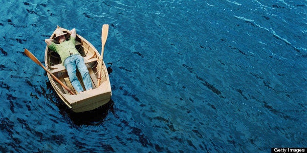 Man lying down in rowing boat, elevated view