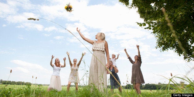 Bride tossing bouquet to wedding party