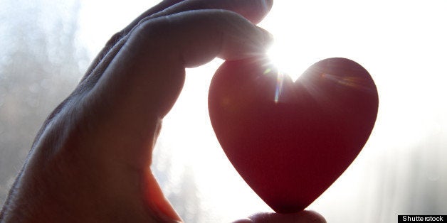 hand holding heart silhouetted ...