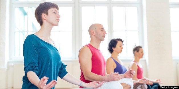 Group of people practising the yoga lotus position