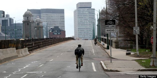 CAMBRIDGE, MA - APRIL 19: A lone bicycle rider makes their way across the Longfellow Bridge to Boston from Cambridge while the Boston Area is under lockdown as a manhunt is underway for a suspect in the terrorist bombing of the 117th Boston Marathon earlier this week. (Photo by Jonathan Wiggs/The Boston Globe via Getty Images)