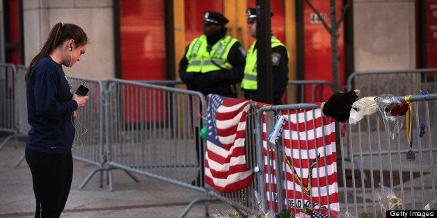 BOSTON, MA - APRIL 17: A woman looks at a street memorial near the scene of twin bombings at the Boston Marathon on April 17, 2013 in Boston, Massachusetts. The explosions, which occurred near the finish line of the 116-year-old Boston race on April 15, resulted in the deaths of three people with more than 170 others injured. Security has been heightened across the nation as the search continues for the person or people behind the bombings. (Photo by Spencer Platt/Getty Images)