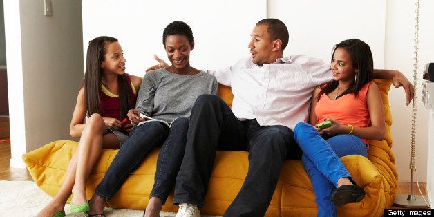 Mixed-race family at home on sofa