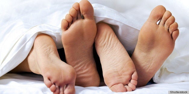 Close-up of the feet of a couple on the bed