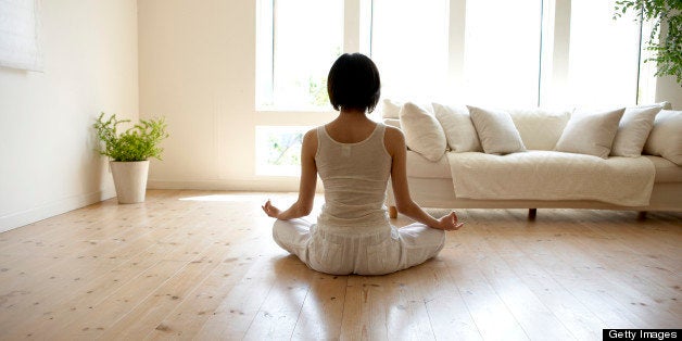 Young woman performing yoga pose in living room