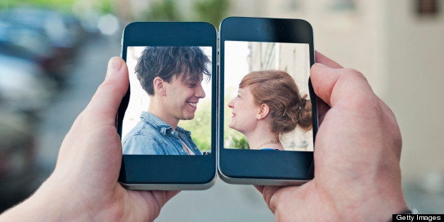 Young couple communicating via two smartphones