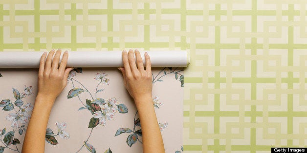 Woman wallpapering wall, close-up