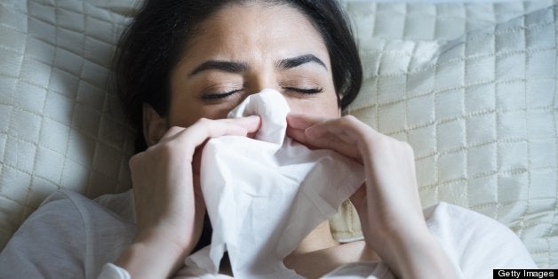 USA, New Jersey, Jersey City, Young woman blowing nose in bed